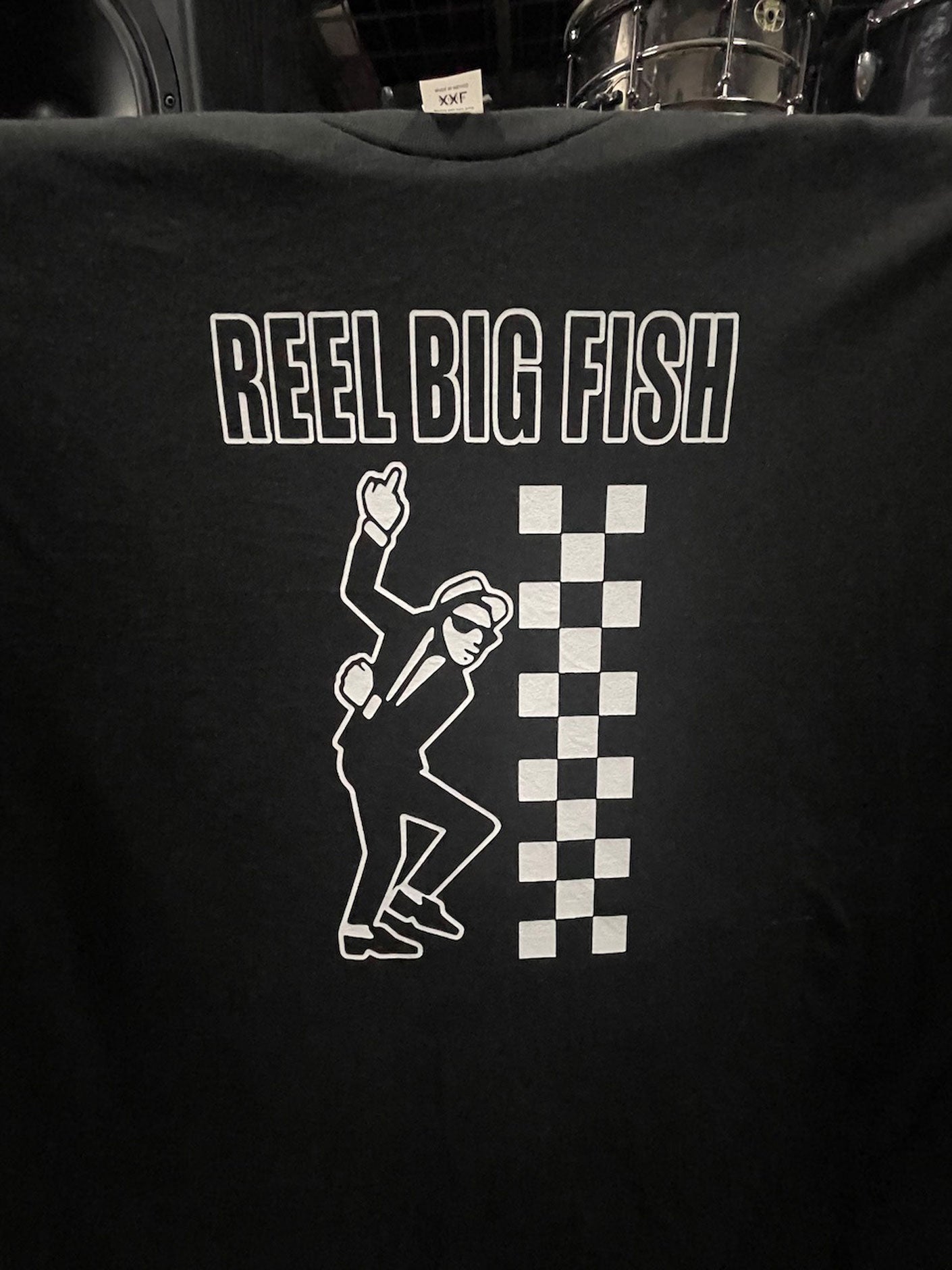 Black t-shirt with 'Reel Big Fish' text and graphic design on a dark background