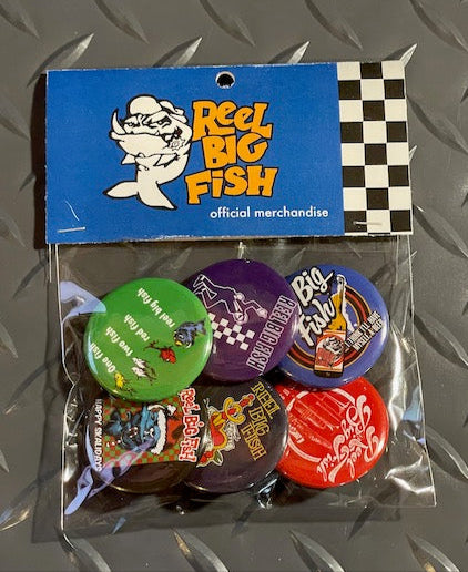 Packaged buttons with 'Reel Big Fish' branding on a metallic surface
